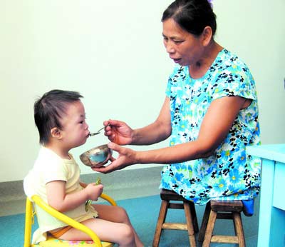 許月華在給孩子喂飯。劉炬 攝