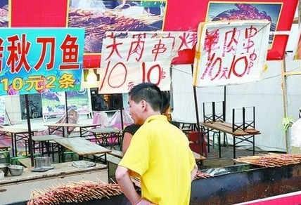 被查后，美食街上的'羊肉串'的'羊'字被涂抹了。