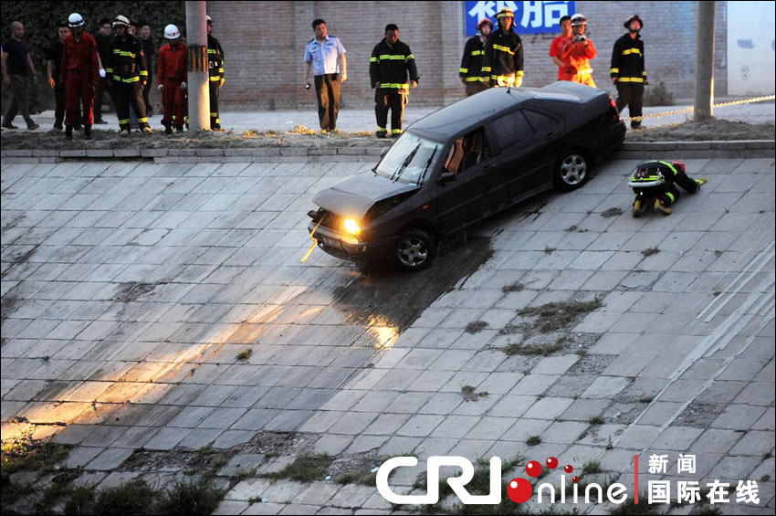 2012年6月17日下午，北京四元橋下方的西壩河輔路上，一輛轎車失控墜河中。消防員將轎車拖上岸。