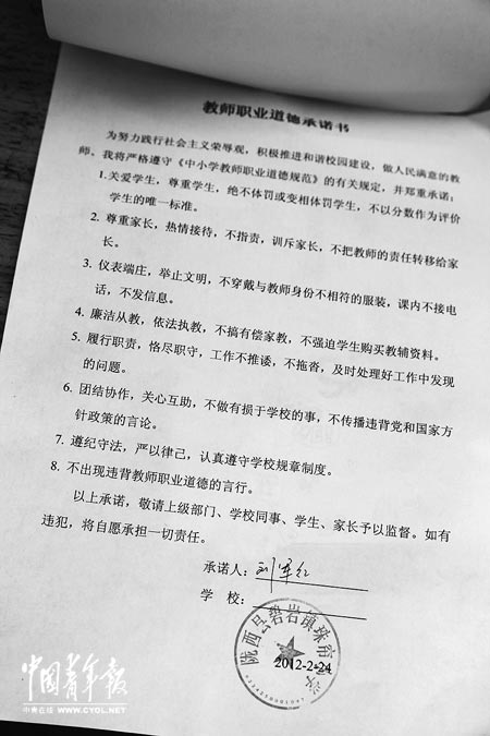 劉軍紅簽字的教師職業(yè)道德承諾書。本報記者 張鵬攝