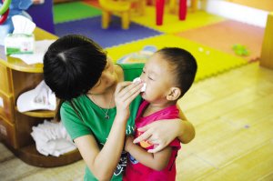 2012年9月3日，浙江一所幼兒園，老師幫孩子擦鼻涕。