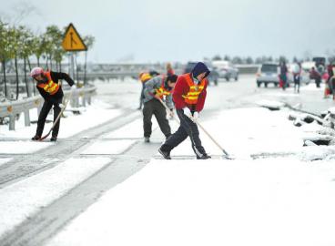 工作人員清理高速路上的積雪。 張磊攝