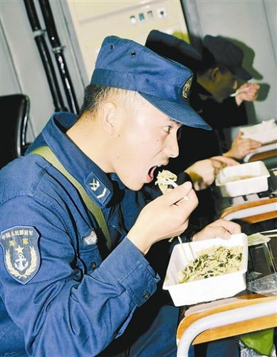 “青島”艦上的官兵在戰(zhàn)位上吃野戰(zhàn)快餐。解放軍報 記者 米晉國攝