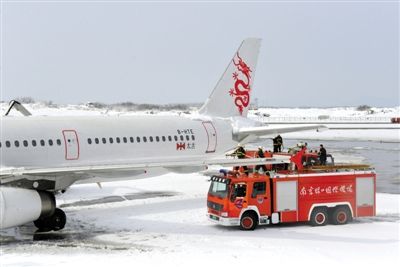 2月19日，南京祿口國際機場工作人員在清理飛機上的積雪。新華社發(fā)