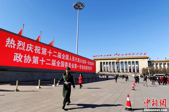 3月4日，北京晴空萬里，武警從北京天安門廣場大型顯示屏前走過。3月5日上午，十二屆全國人大一次會議將隆重開幕。中新社發(fā) 劉忠俊 攝