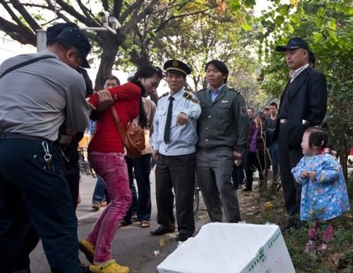 城管與女小販發(fā)生沖突后，女小販被警方強行帶走，她的孩子在一旁放聲大哭。南都記者 黎湛均 攝